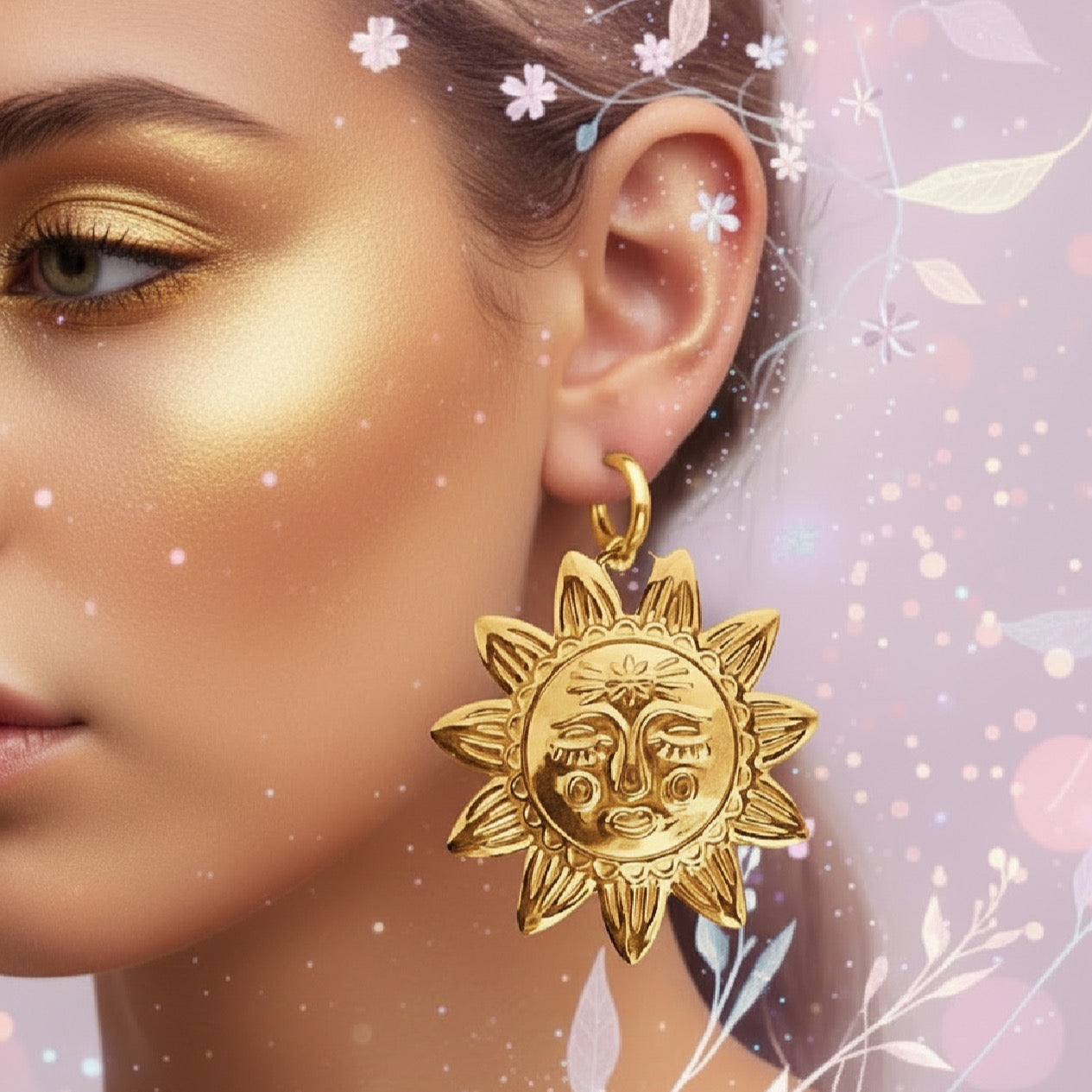 Helios Grande Sun Statement Hoops | Gold. Gold hoop earrings with a large gold sun charm with face details worn by a model, with gold make up on a colourful background.