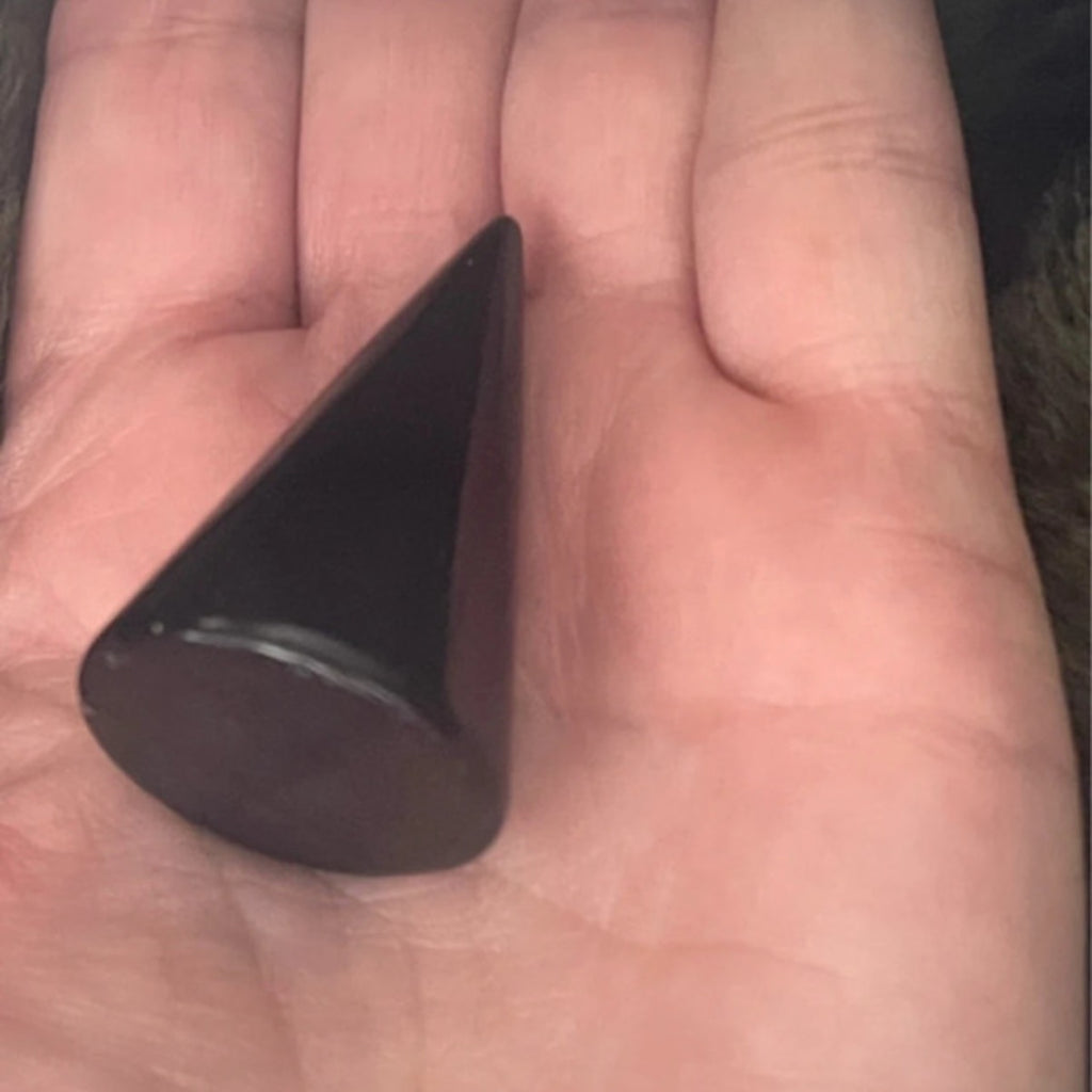 Black triangular object held in a hand