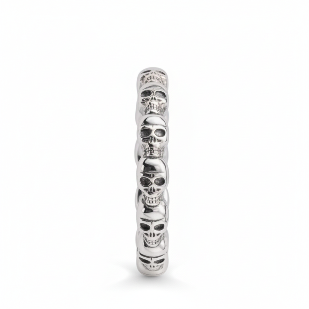 A silver-toned skull ring featuring  detailed skulls, shown on a clean white background.