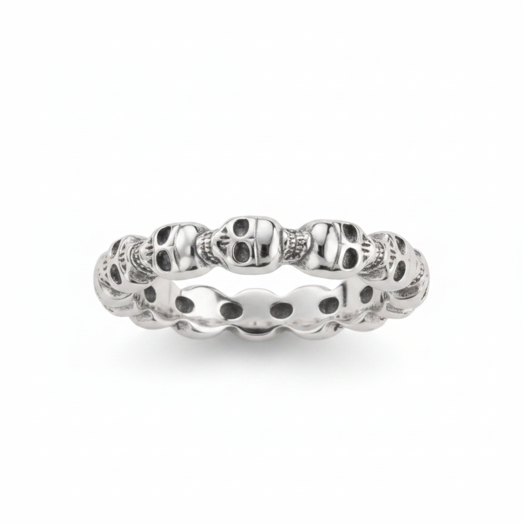 A sterling silver eternity band ring featuring a continuous row of small skulls photographed on a clean white background.