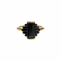 A gold ring featuring a central rectangular black gemstone surrounded by smaller stacked black rectangular stones, set on a plain white background, kookikent.