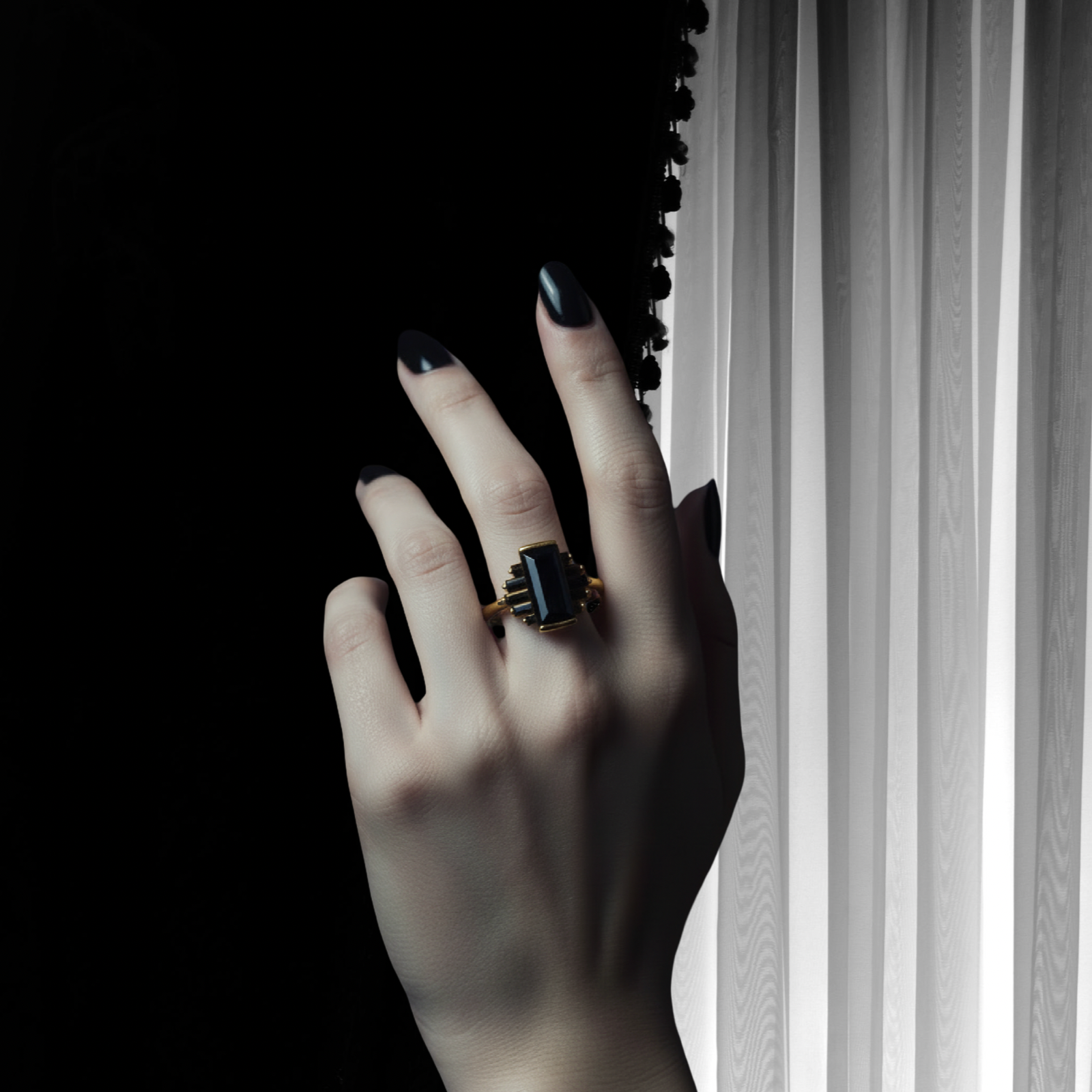 A hand with dark painted nails wears a gold ring featuring a large black rectangular stone, posed against a stark black background and white vertical blinds.