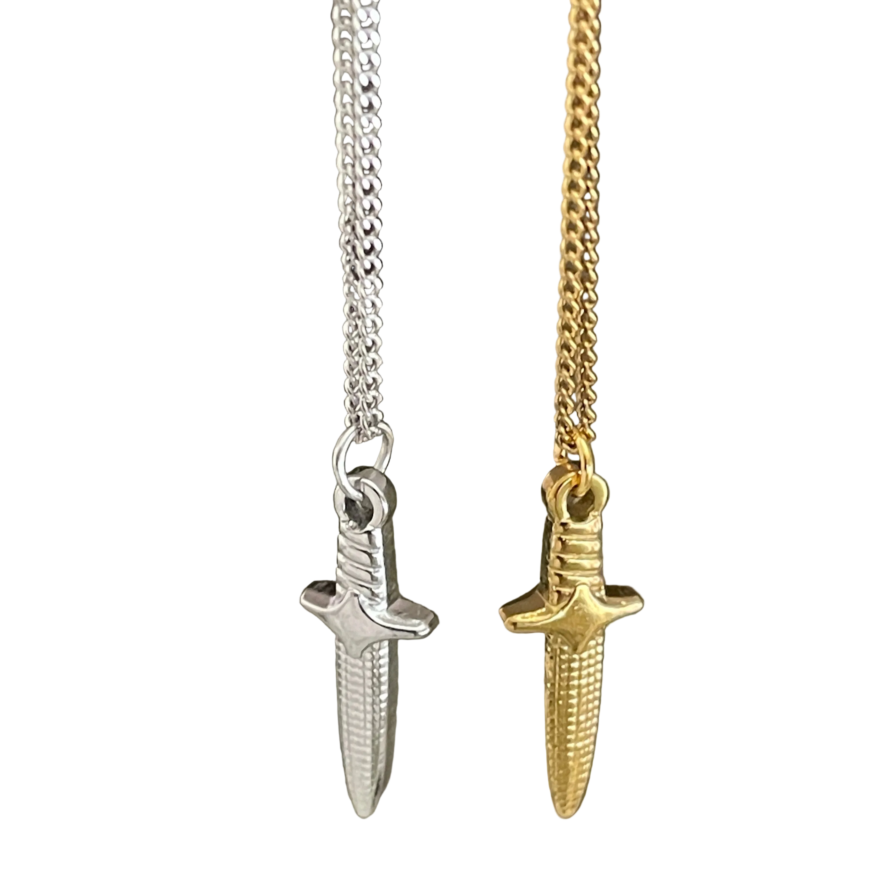 Two dagger-shaped pendants on chains, one silver and one gold, on a white background.