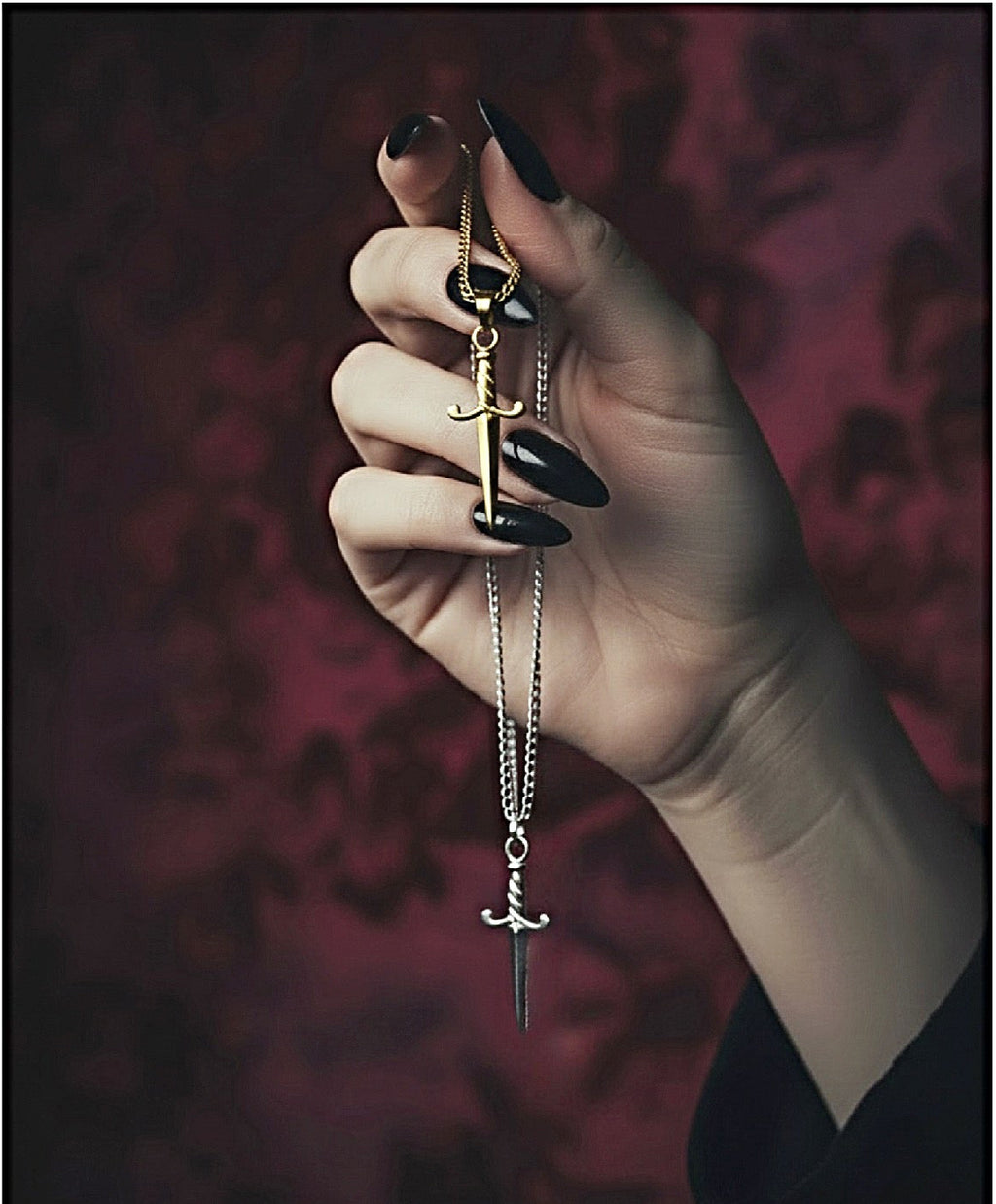Hand holding a necklaces with a pendant against a dark background