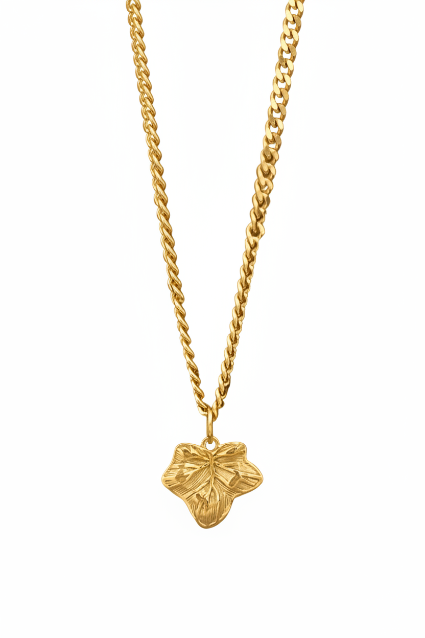 A gold chain necklace with a textured, leaf-shaped pendant, shown against a plain white background.