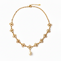 A gold-tone chain necklace featuring a series of small flower-like links with a single white pearl pendant hanging at the center, shown on a plain white background.