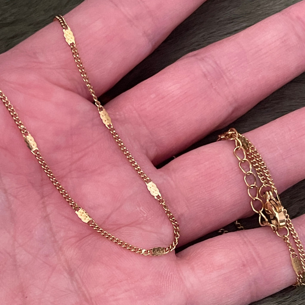 Gold chain necklace on a hand