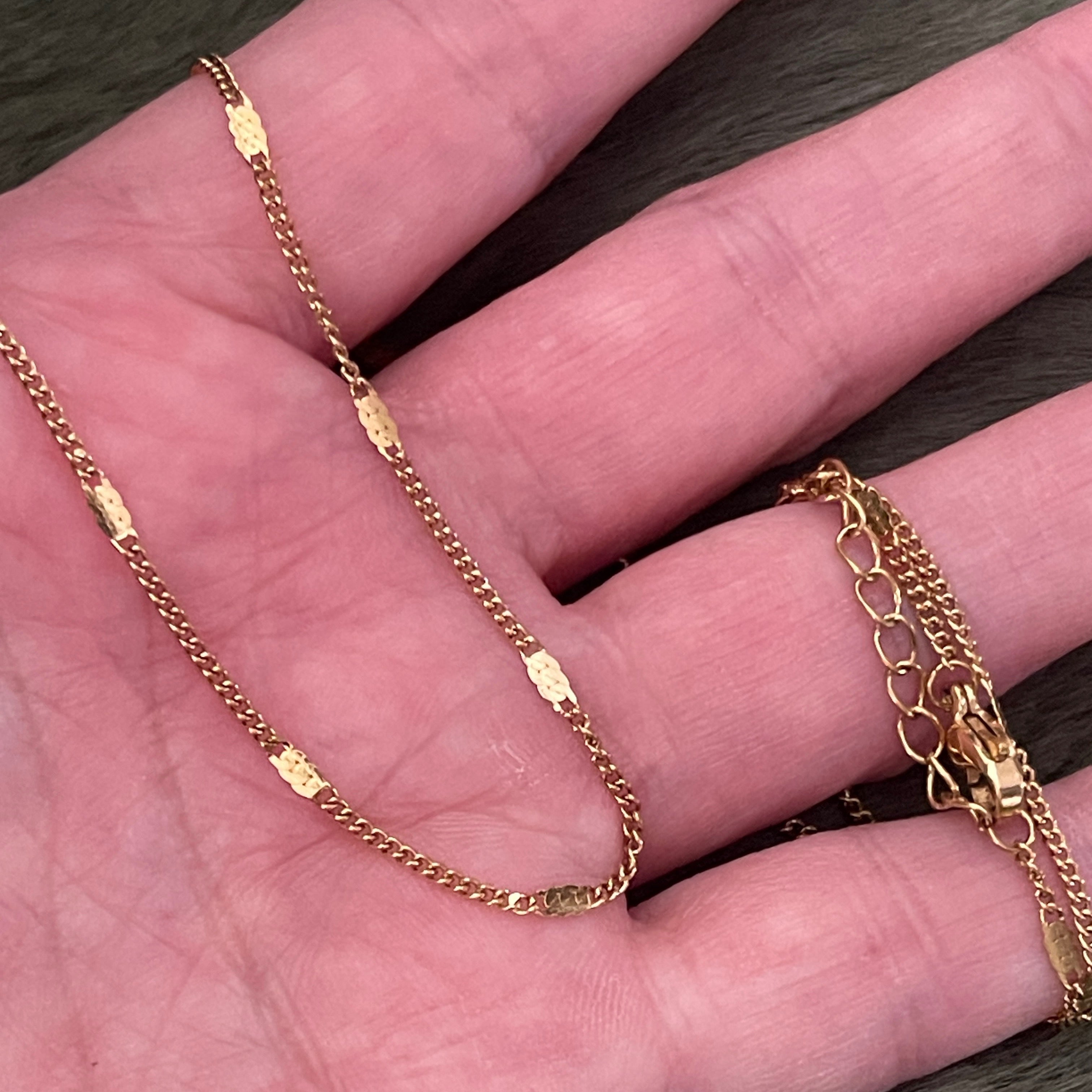 Gold chain necklace on a hand
