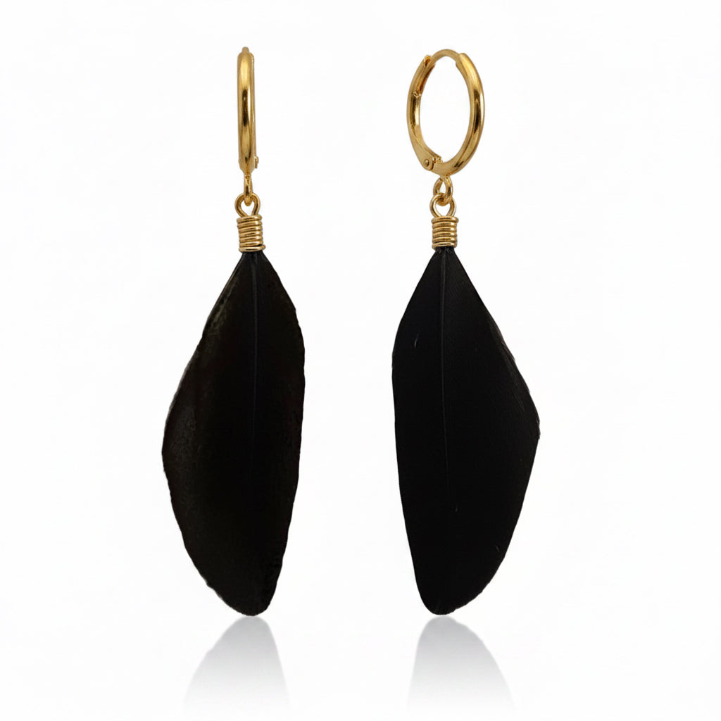 A pair of black feather drop earrings with gold hoop backings, displayed against a clean white background with a subtle reflection.