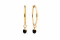 A pair of gold hoop earrings with a small oval black agate crystal against a white background