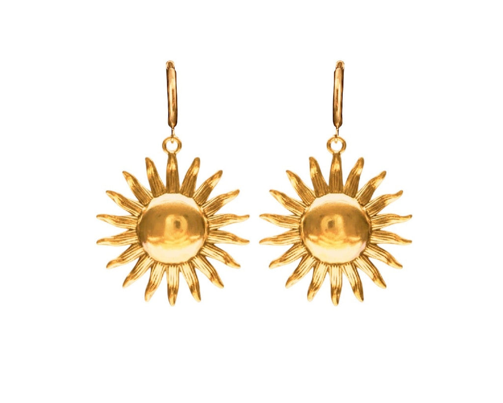 A pair of gold sunburst drop earrings with a polished circular center and radiating pointed rays, shown against a plain white background.
