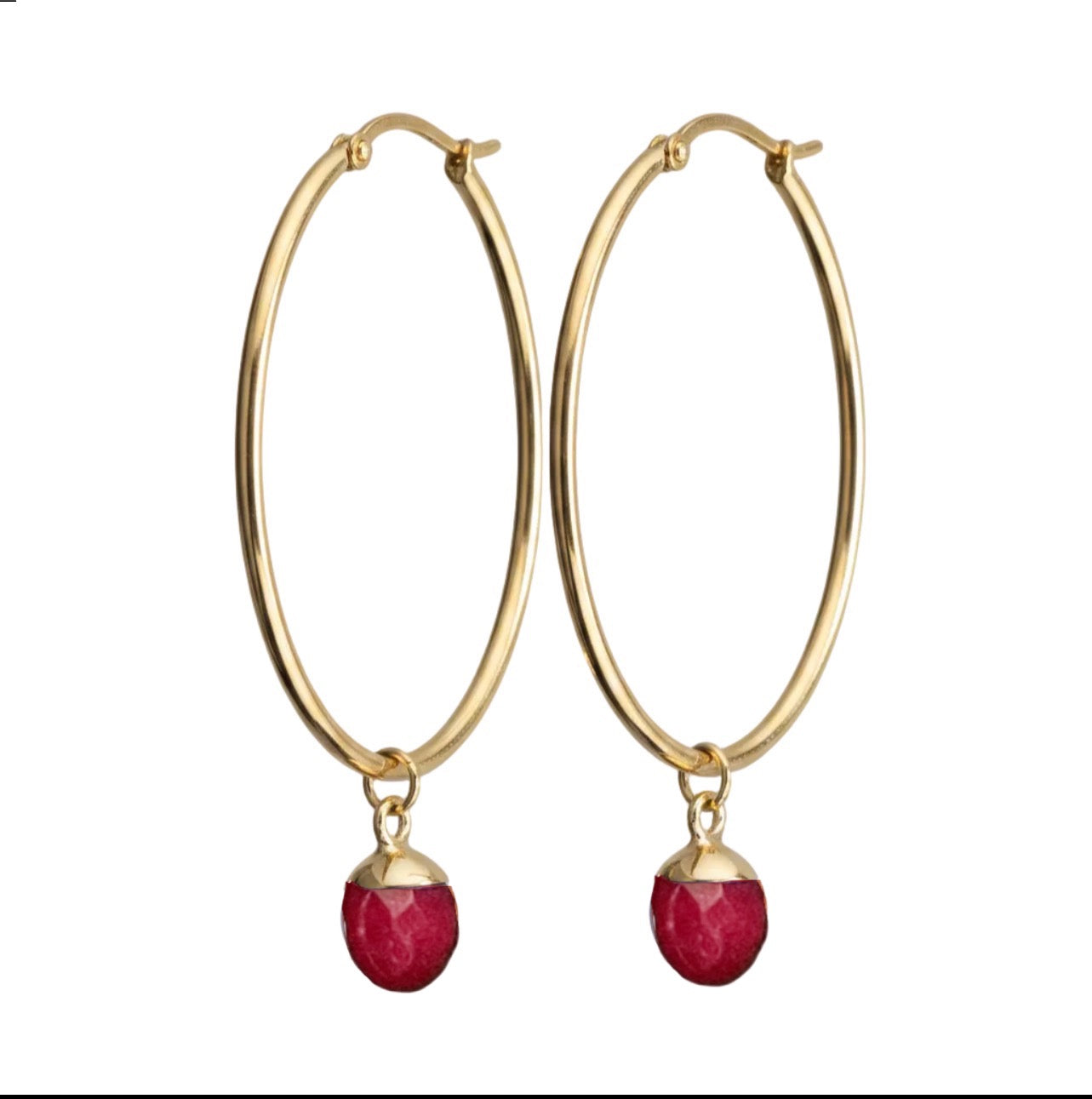 Gold hoop earrings with red gemstones on a white background