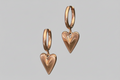 Heart-shaped gold earrings on a gray background