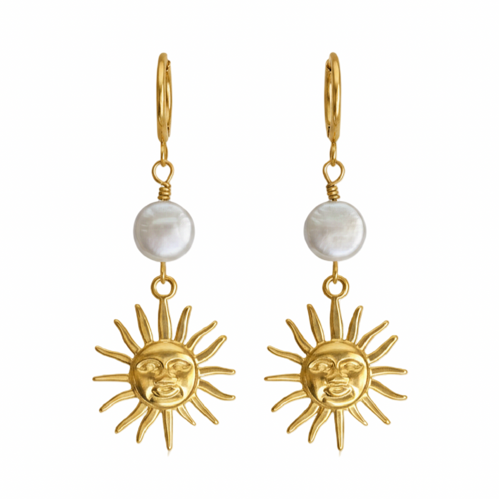 A pair of gold-tone dangle earrings featuring a small round white pearl and a dangling sun face charm, shown against a plain white background.