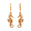 Gold seahorse earrings on a white background