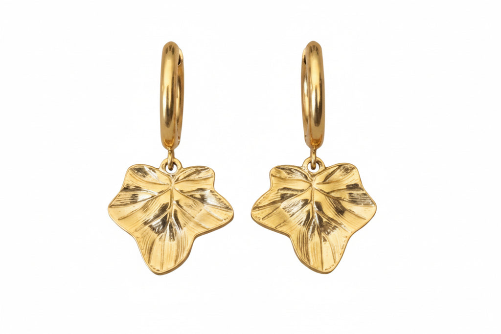 A pair of gold hoop earrings featuring textured ivy leaf charms shown against a plain white background.