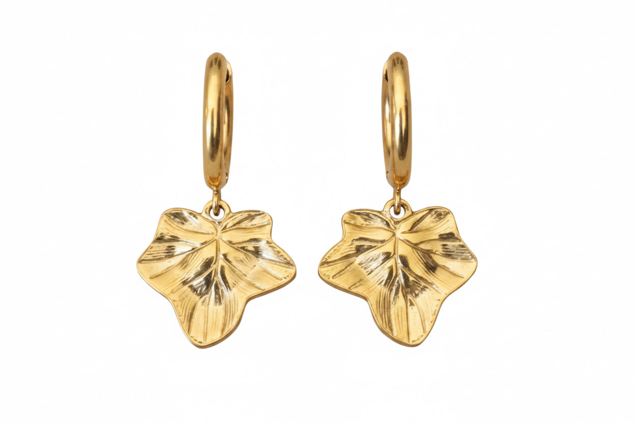 A pair of gold hoop earrings featuring textured ivy leaf charms shown against a plain white background.