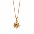 Gold sun-shaped pendant on a chain against a white background