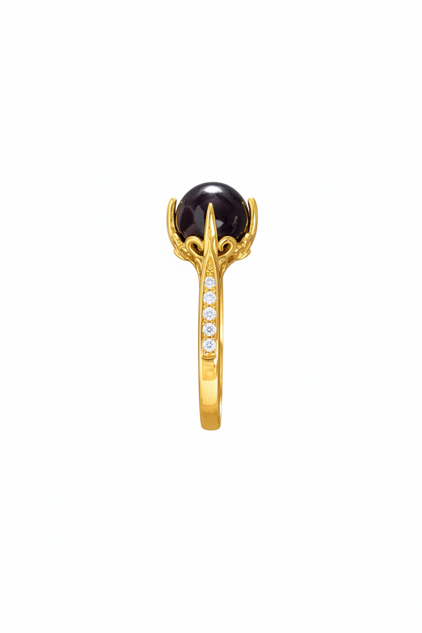 A gold ring featuring a large, round black pearl in a claw setting, with a channel-set row of small clear stones along the band, shown against a plain white background.