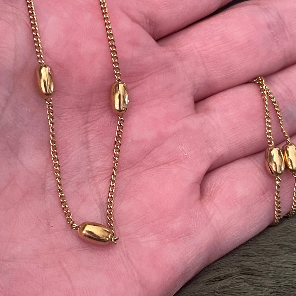 Gold chain necklace on a hand
