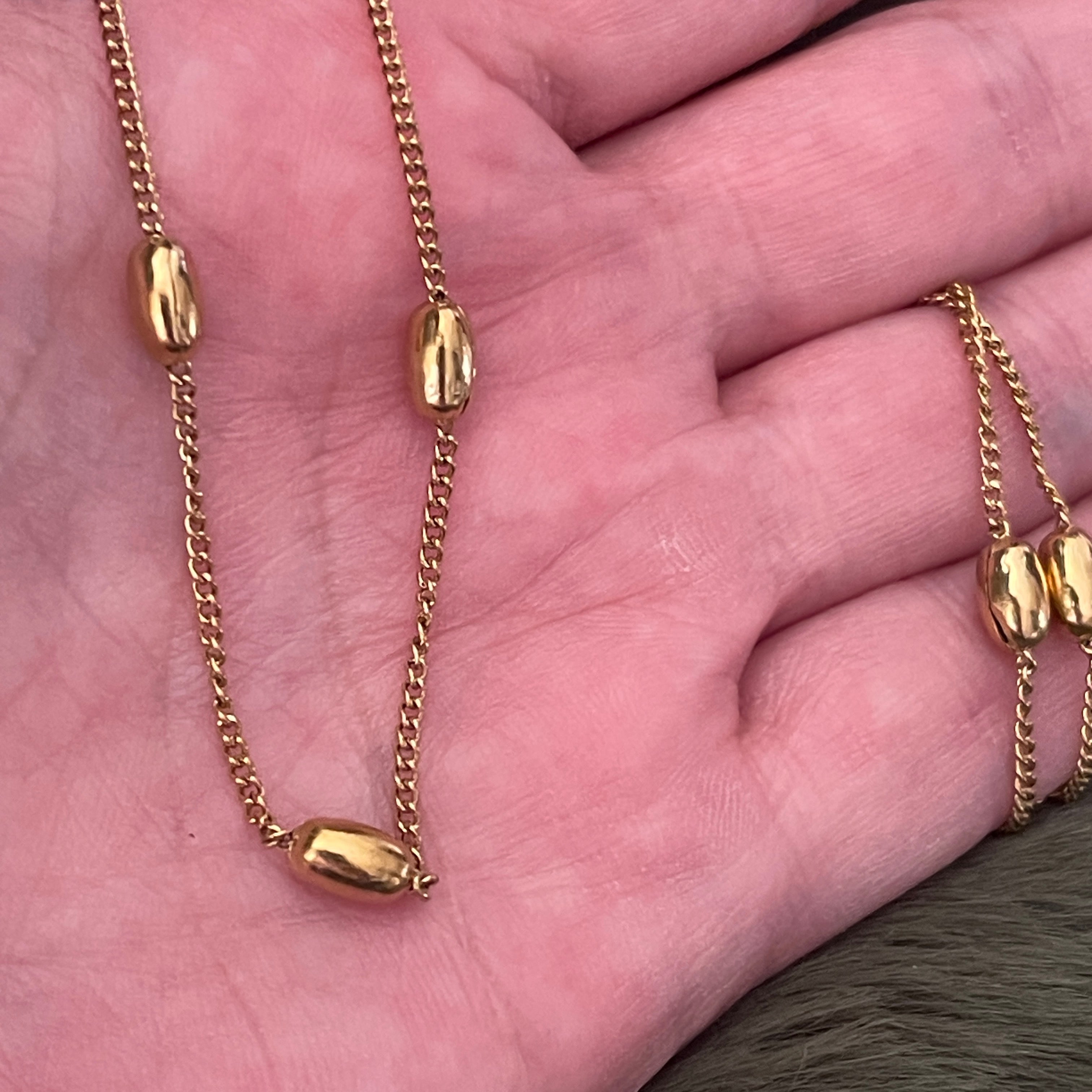 Gold chain necklace on a hand