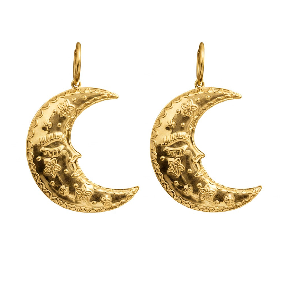 Gold crescent moon earrings with intricate face designs on a white background