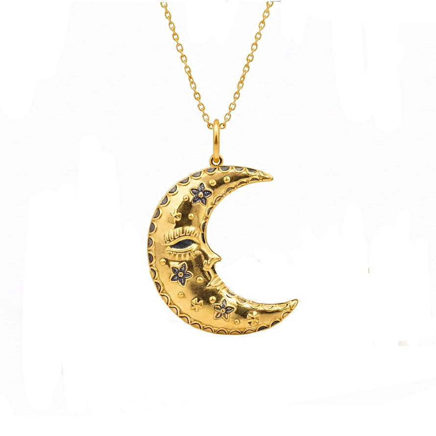 Gold crescent moon necklace with face details on a white background