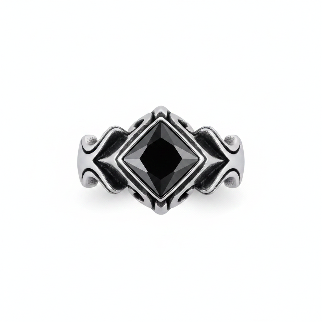 A silver-toned gothic-style ring featuring a large, faceted black diamond-shaped gemstone in the center, set against a clean white background.