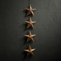 Hand holding a set of star-shaped bronze ornaments against a green textured background