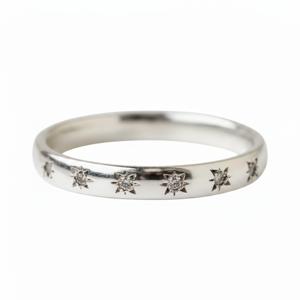 A silver band ring featuring a row of small, starburst-shaped diamond motifs set along the front, shown against a plain white background.