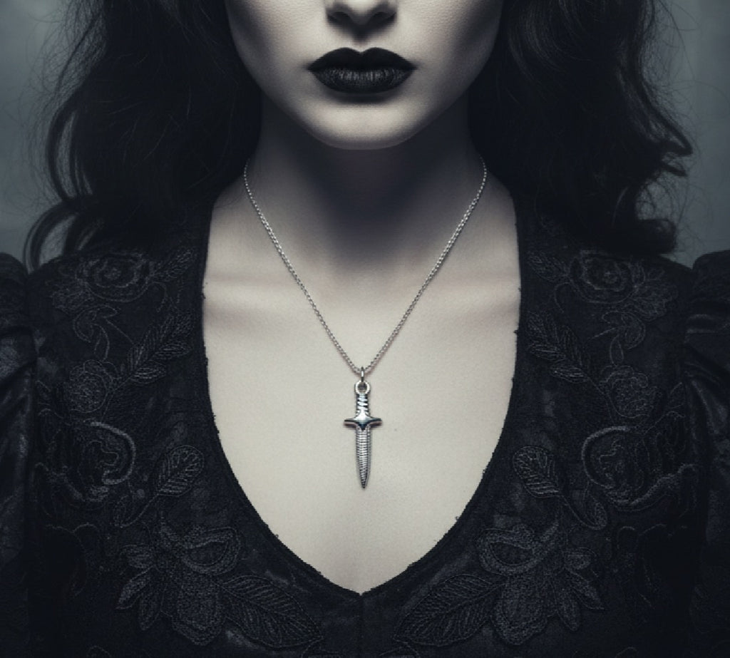 Person wearing a black lace garment with a silver dagger pendant necklace.