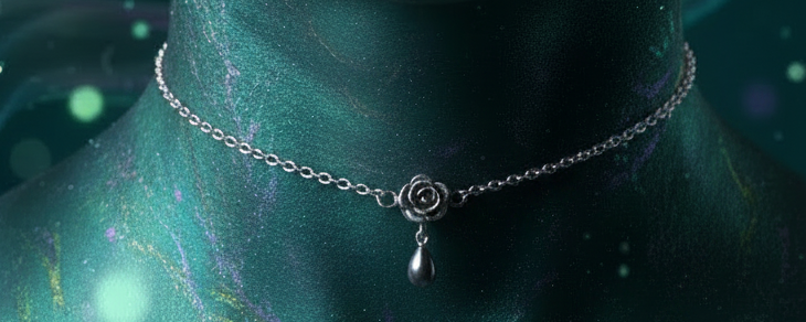 A silver-toned delicate chain necklace with a small rose charm and teardrop pendant, displayed on a metallic teal neck mannequin against a dark teal background.