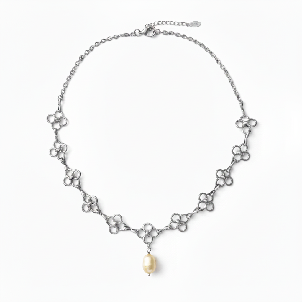 A silver-tone chain necklace featuring a series of small interlocking floral or clover-like motifs with a single dangling pearl at the center, shown on a clean white background.