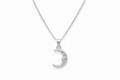 Silver moon-shaped pendant on a chain against a white background