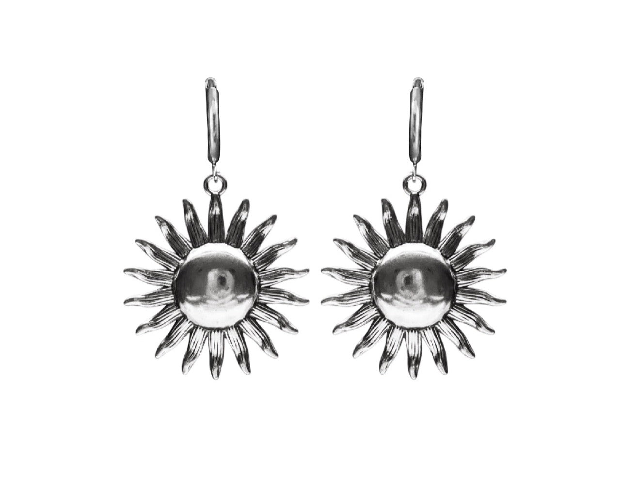 A pair of silver sunburst drop earrings with a polished central circle and textured radiating points, shown against a plain white background.