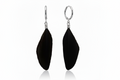 A pair of black feather drop earrings with silver-toned metal hooks and wire-wrapped details, shown against a plain white background with a subtle reflection below.
