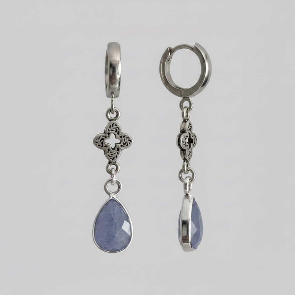 Pair of silver hoop earrings with blue teardrop pendants on a gray background