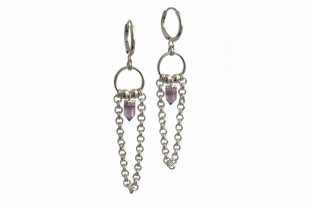 Silver hoop earrings with chainmail detail and an amethyst crystal on a white background.
