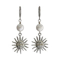 A pair of silver drop earrings featuring a round white pearl and a dangling sun face charm, shown against a plain white background.