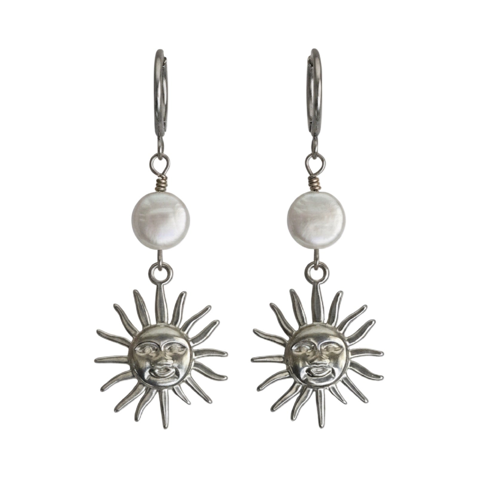 A pair of silver drop earrings featuring a round white pearl and a dangling sun face charm, shown against a plain white background.