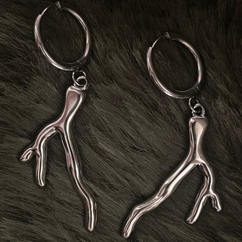 Silver earrings with silver coral charms on a fur background 
