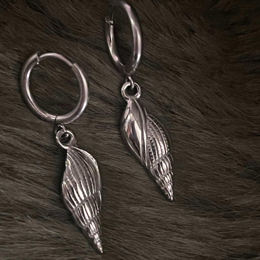 Silver shell earrings on a fur background 