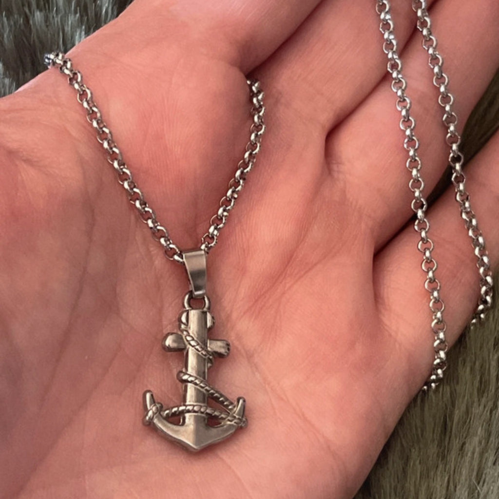 Silver anchor necklace on a hand