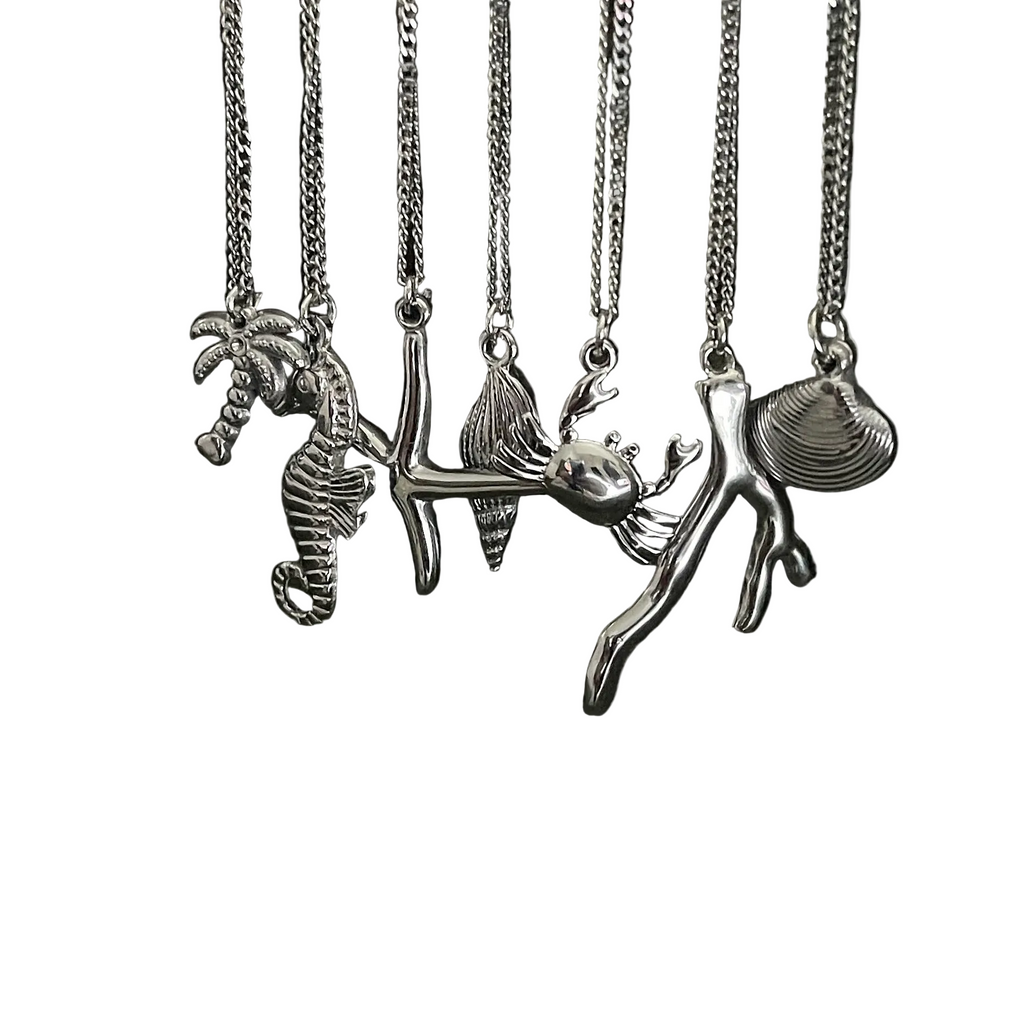 Set of silver necklaces with various sea-themed pendants on a white background