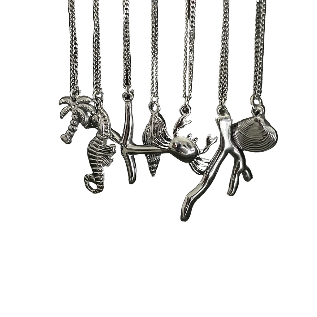 Set of silver necklaces with various sea-themed pendants on a white background