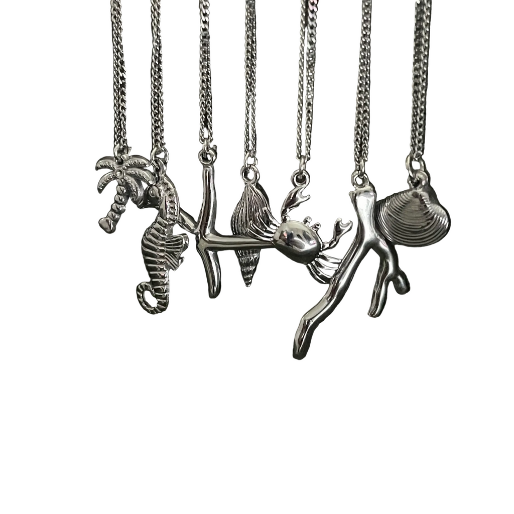 Set of silver necklaces with various pendants on a white background