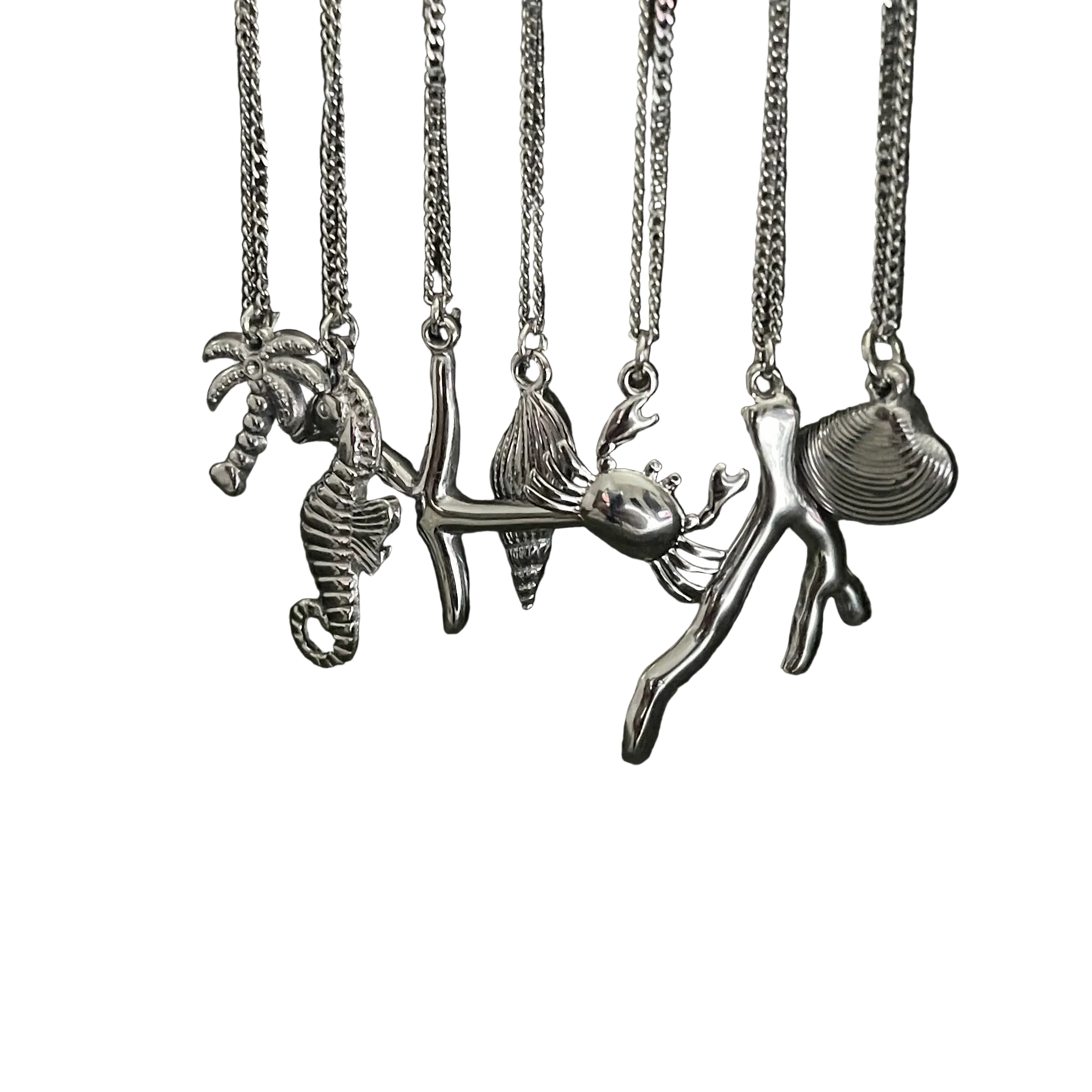 Set of silver necklaces with various pendants on a white background