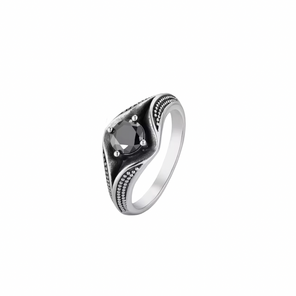 Silver ring with a black cubic zirconia gemstone and surrounded with a dot detail on a white background.