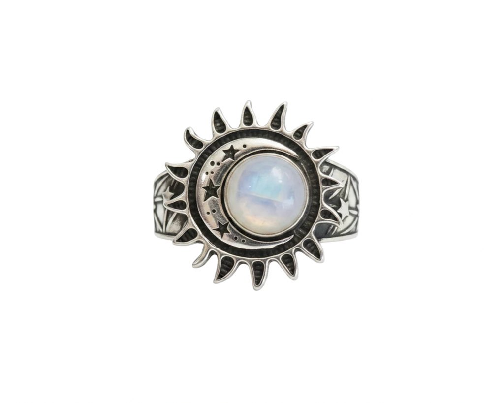 A silver sun and moon ring featuring a central round moonstone with a soft blue and white iridescent sheen, set against a plain white background.