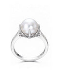 A silver ring featuring a large white pearl in a prong setting with small clear stones along the band, shown against a plain white background.